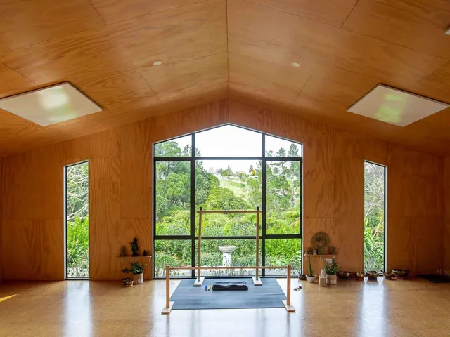 Timber-lined retreat hall with large windows overlooking the gardens