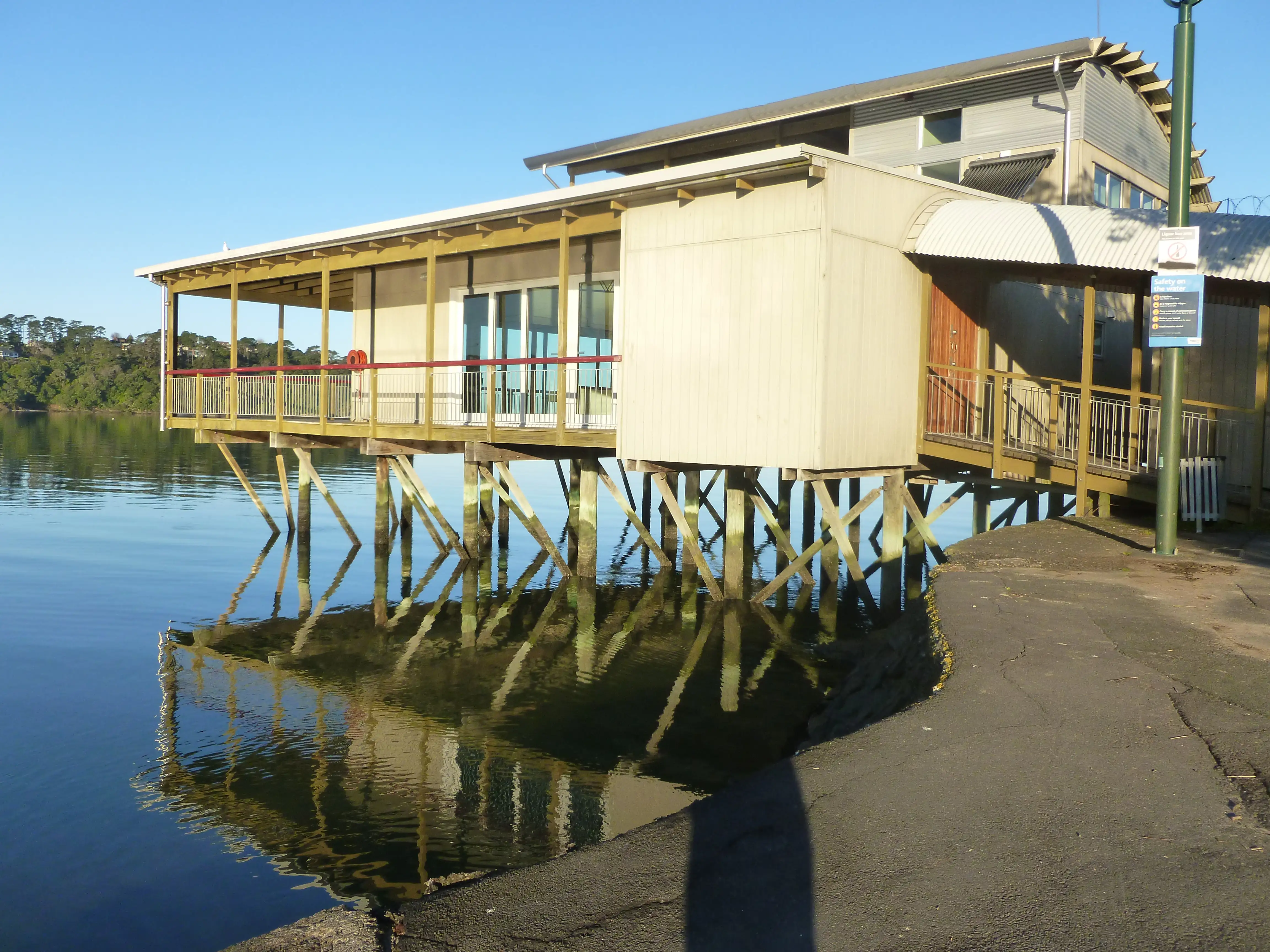 Blockhouse Bay Boat Club on the waterfront, reflected in the calm bay